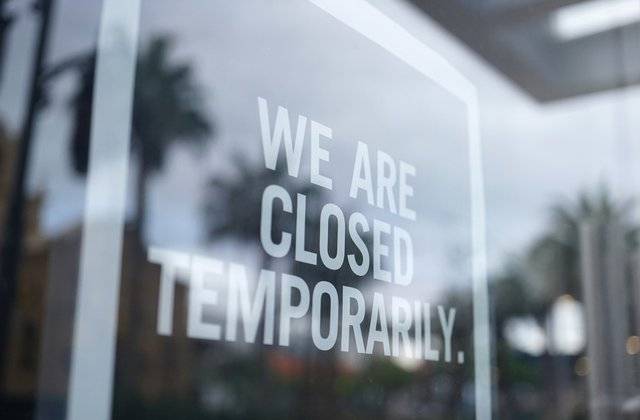 temporarily closed sign in window of business